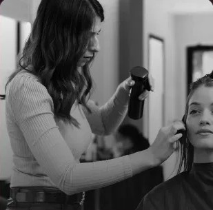 Cabeleireira finalizando o cabelo de uma cliente